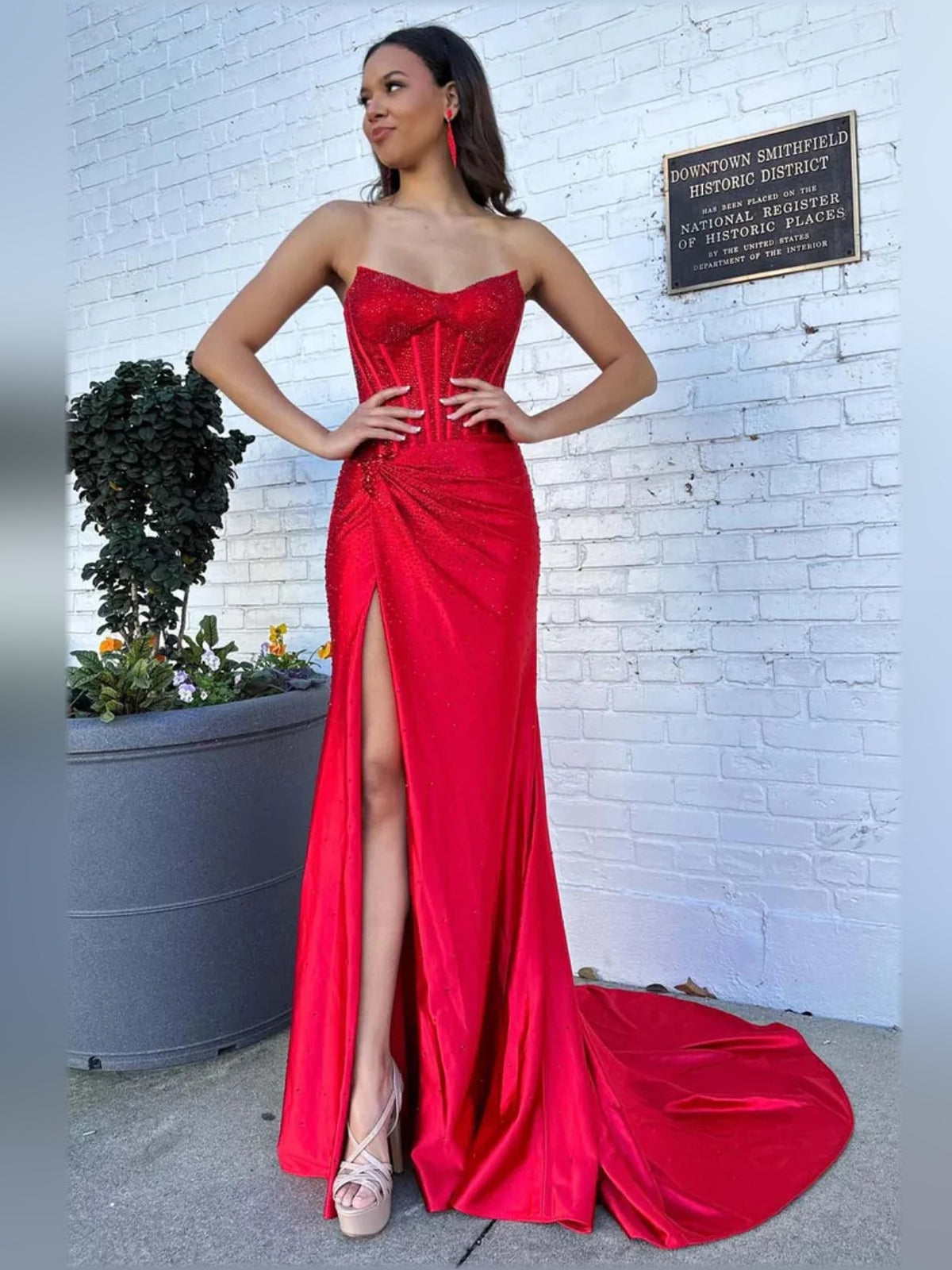 Red sweetheart corset formal dress with front slit and full-length flowing skirt