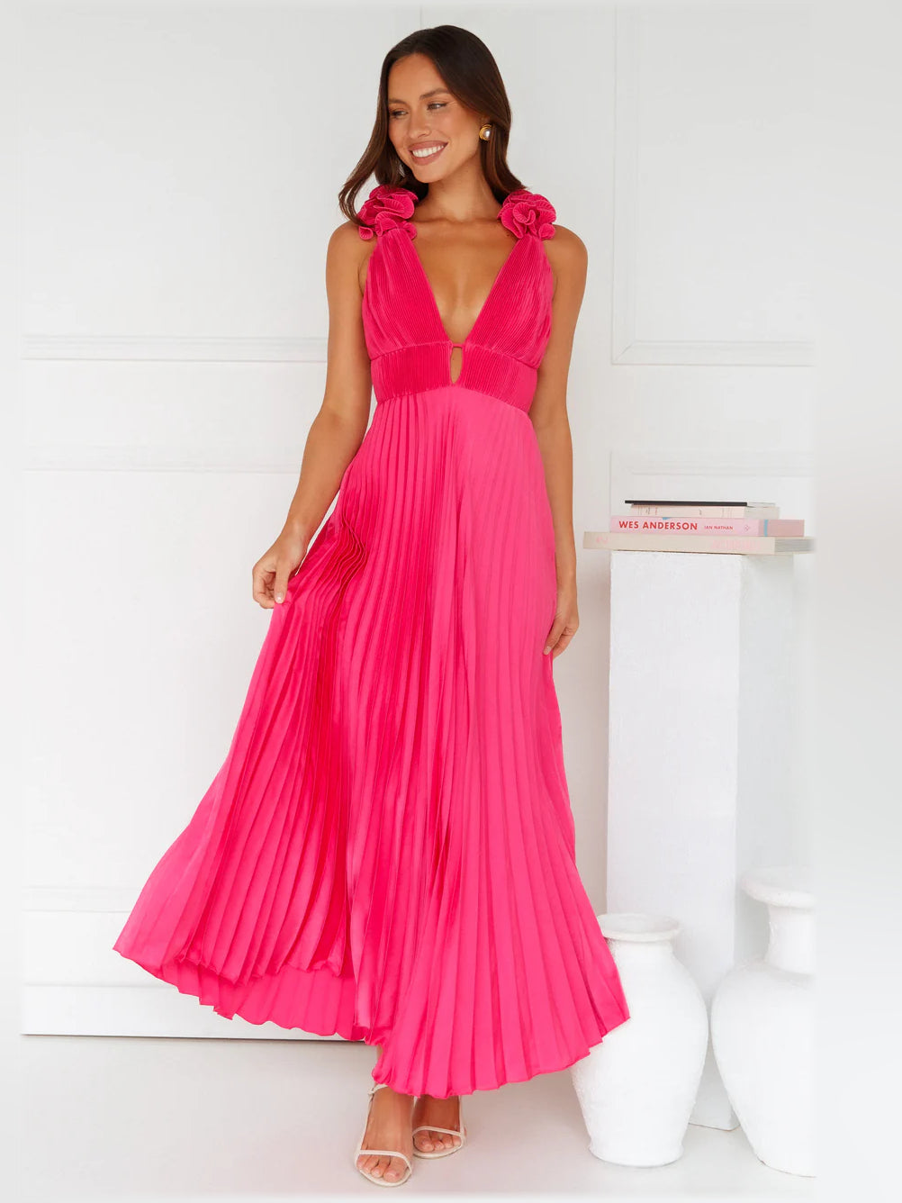 Pink satin midi formal dress with V-neck, bow shoulder straps, and pleated skirt