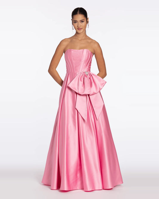 Pink strapless corset ball gown with ruffled bow at waist and floor-length skirt